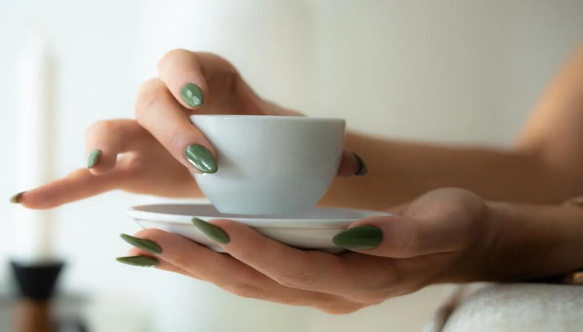 Olivgrüne Nägel an einer Teetasse